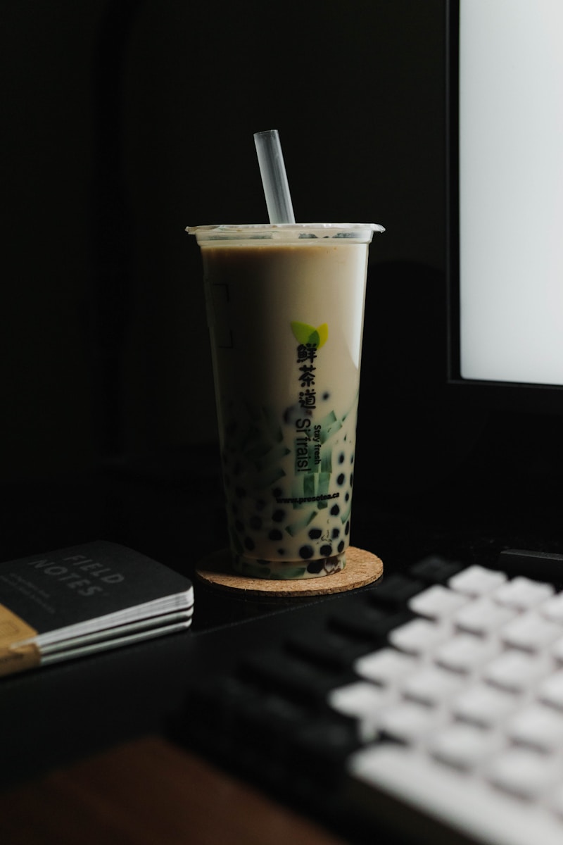 a cup of coffee sitting next to a computer keyboard