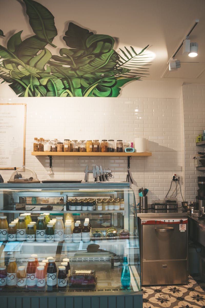 Interior of a modern juice store with plant decor and various juices on display.